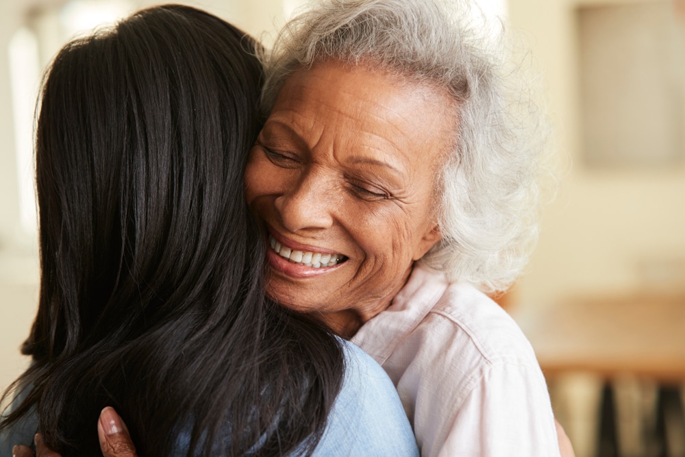 An older woman hugs her daughter after getting custom dentures at Sheridan Dental in Grove City, OH