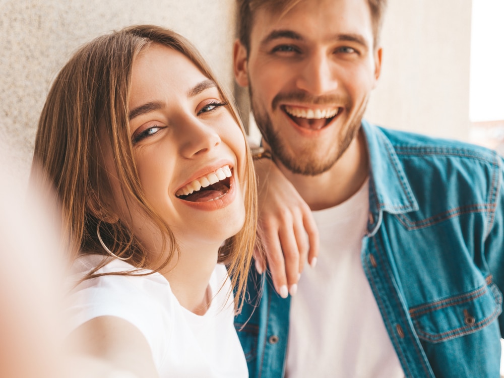 A man and woman share a joyful moment, laughing together in a warm and friendly atmosphere.