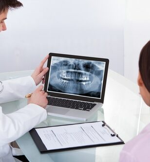 A dentist showing a client an X-ray of their teeth.