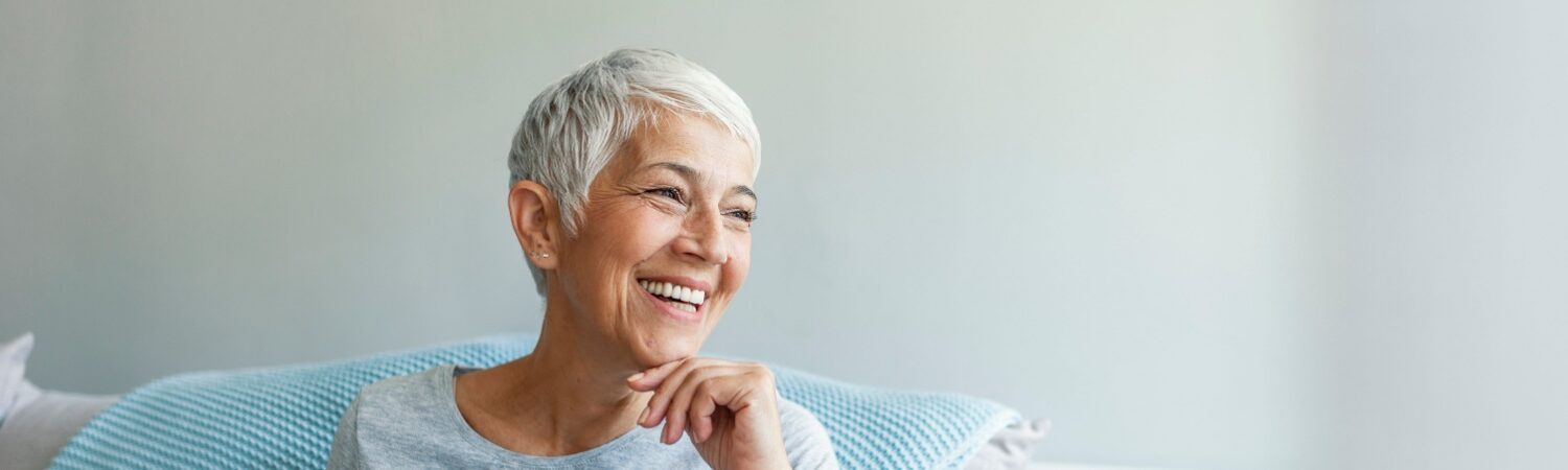 A mature woman with short hair smiling thinking about her restorative dentistry treatment in Grove City.