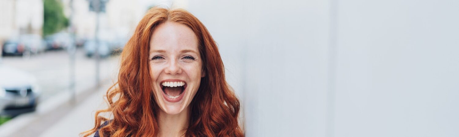 A young woman who has fixed cracked teeth with a porcelain crowns from Sheridan Dental Group.