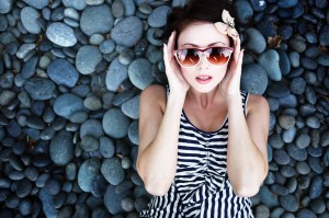 A young woman reclining on stones after a relaxing dental exam in Grove City.